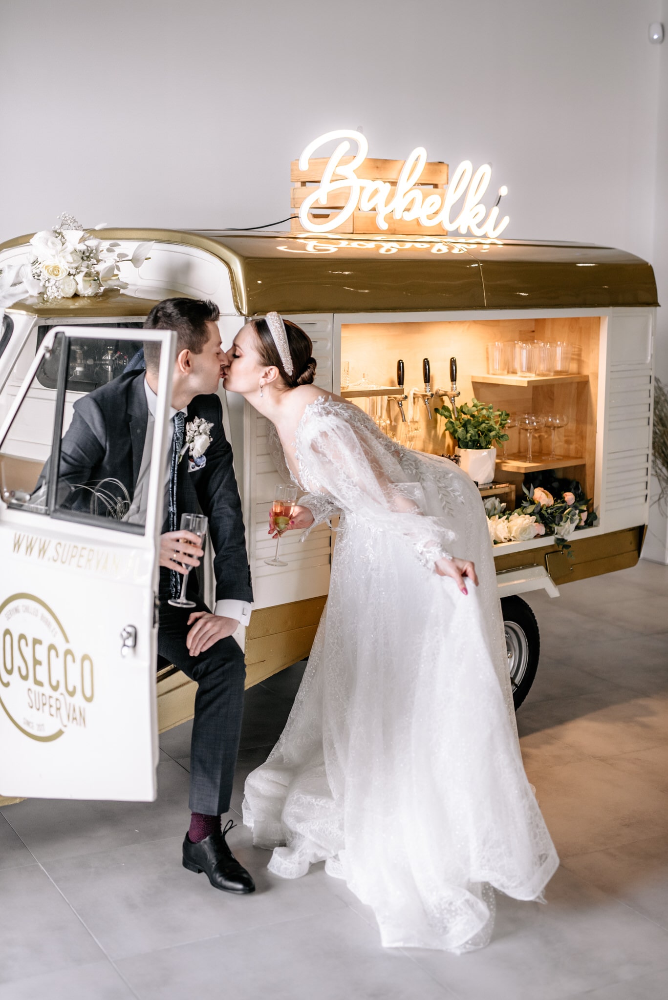 Bride and groom kissing in front of prosecco van