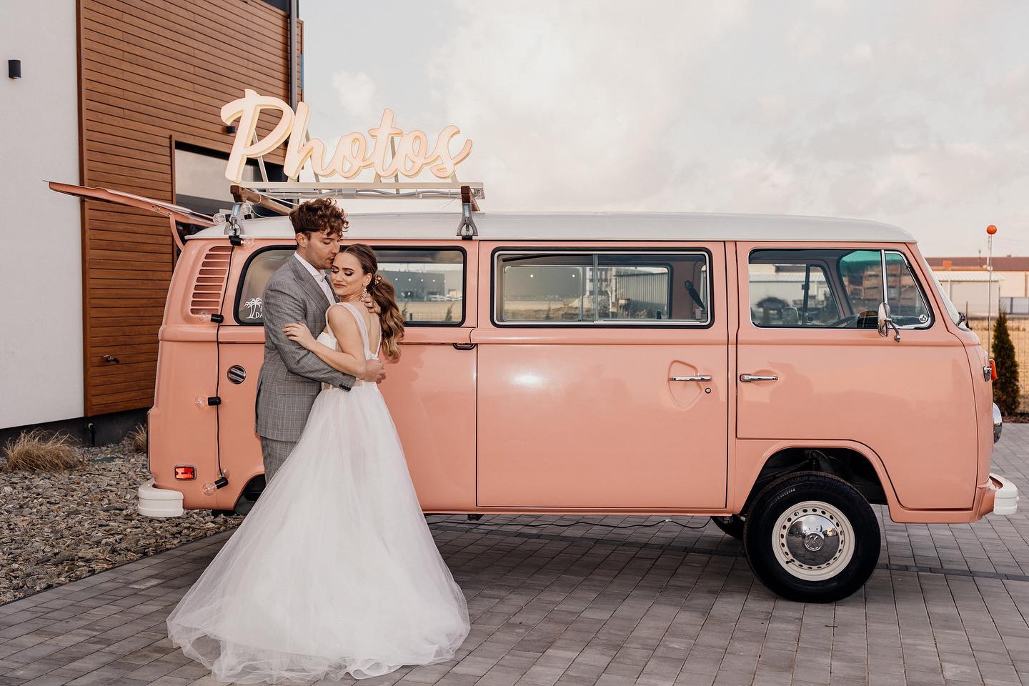 Wedding couple posing in front of a pink van